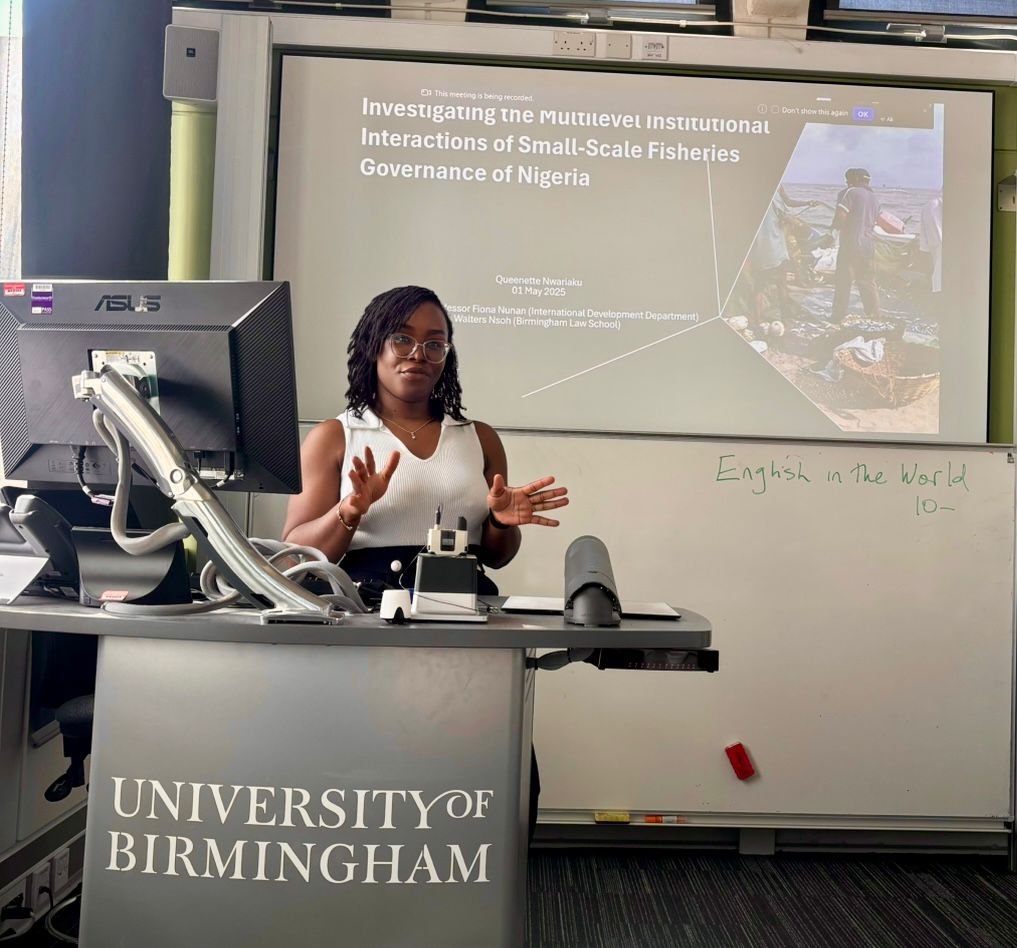 A Black woman presenting at a University of Birmingham podium.